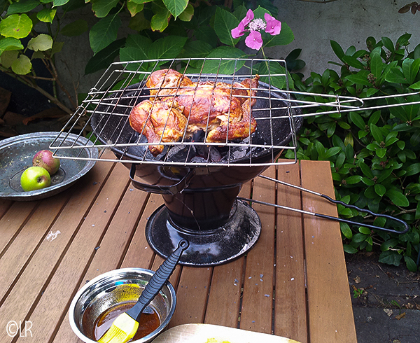 Bruin gegrilde kip op een kleine barbecue met een schaaltje piri-piri saus