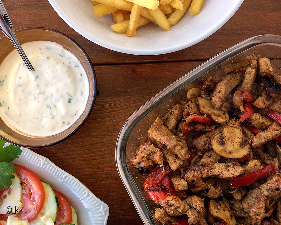 Schaal shoarmavlees met champignons en paprika met een salade, romige knoflooksaus en frietjes