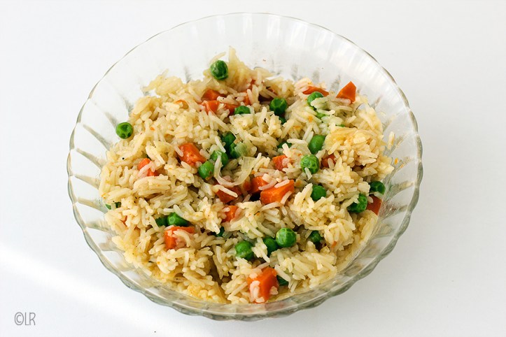 Heerlijke vegetarische rijstschotel als bijgerecht, weer eens wat anders dan een aardappeltje. Schaal met rijst waarin de doperwtjes en wortel goed te zien is.