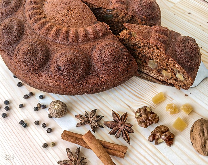 Kruidkoek uit de Zeeuwse knop met gember en walnoten. Er omheen liggen specerijen die voor de koekkruiden zijn gebruikt.