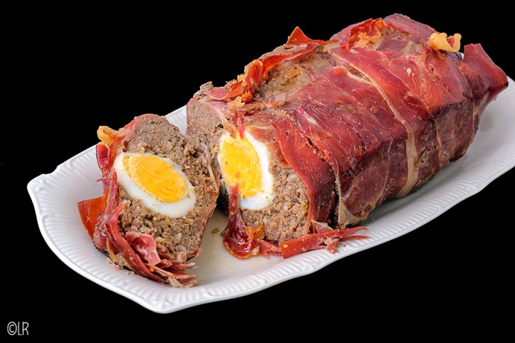 Een traditioneel meat loaf (gehaktbrood) met eieren. Op een schaaltje een gehaktbrood (meat loaf) ingepakt in rauwe ham en met hardgekookte eieren.