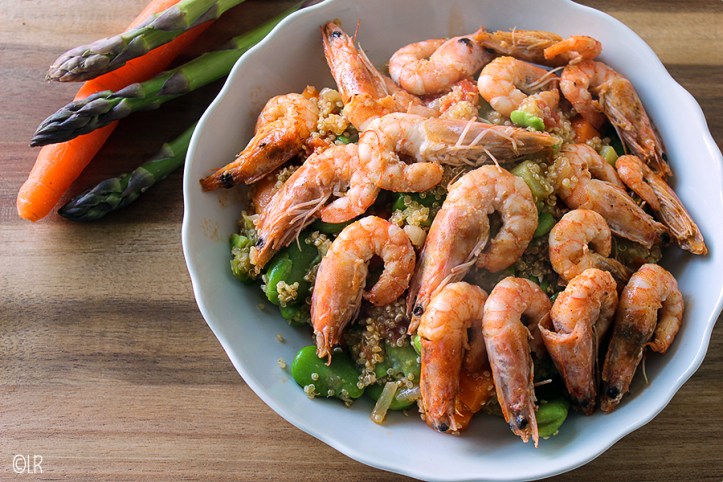 Schotel met Quinoa met veel groenten en erop in knoflookolie gebakken garnalen.