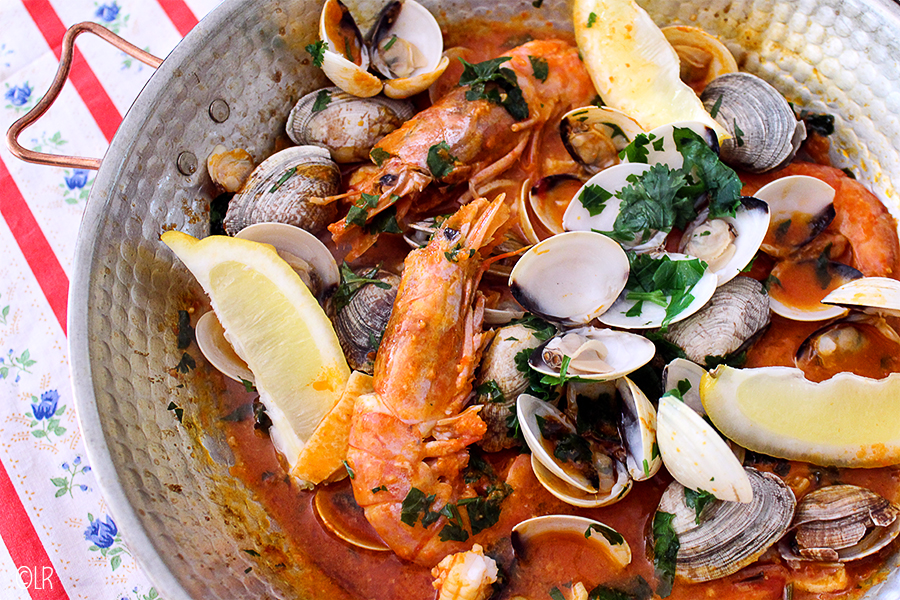 Traditionele koperen cataplana gevuld met venusschelpen, gamba's en stukjes vis