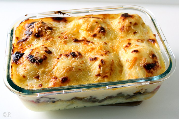 Ovenschotel van gehakt, aardappelpuree en bloemkool met een kaassaus.