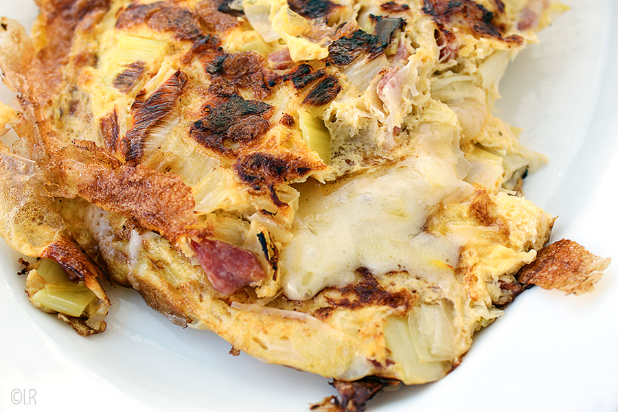 Goed gevulde omelet met prei, spekjes met een kern van gesmolten kaas.